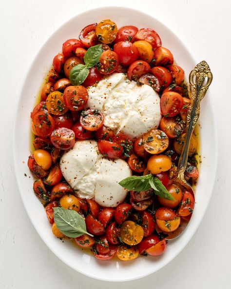 Burrata Caprese is a twist on the classic Caprese salad. Marinated cherry tomatoes on top of creamy burrata drizzled with olive oil and flakes of sea salt. This recipe is fresh flavorful and perfect for summer! Caprese Salad Burrata, Tomato Buratta, Marinated Tomato Salad, Marinated Cherry Tomatoes, Burrata Caprese Salad, Tomato Burrata Salad, Burrata Caprese, Caprese Recipes, Caprese Salad Recipe