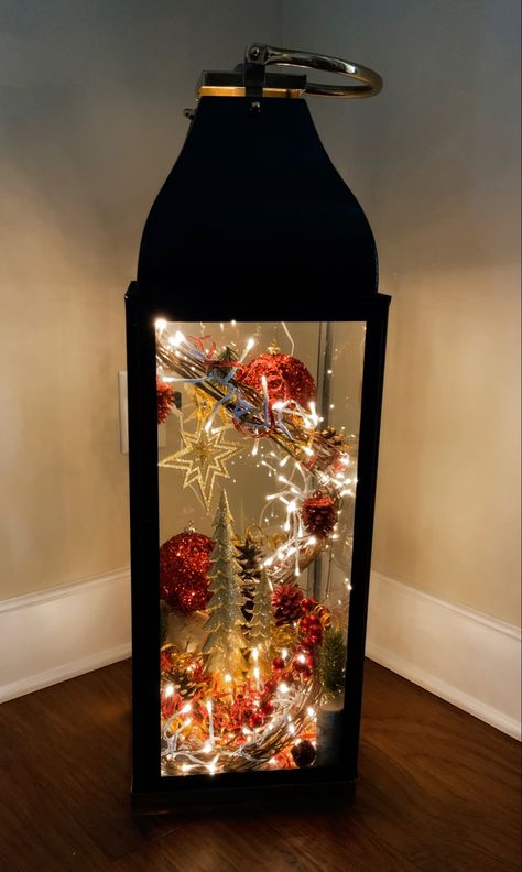 Found this metal and glass lantern 30”x10”x10” at Home Goods and sprayed it black. All decorations came from Hobby Lobby. Fun little project that will last for years! Black Lantern Decor, Lantern Christmas Decor, Lantern With Fairy Lights, Lantern Decor, Lantern Christmas, Christmas Lantern, Lamp Lights, Large Lanterns, Black Lantern