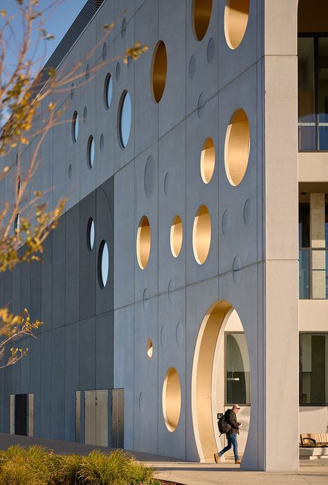 playful, circular windows punctuate buchan's library expressive facade in australia Circles In Architecture, Flexible Furniture, Timber Screens, Rammed Earth Wall, Glass Curtain Wall, Rammed Earth, Mix Use Building, Living Water, Main Entrance