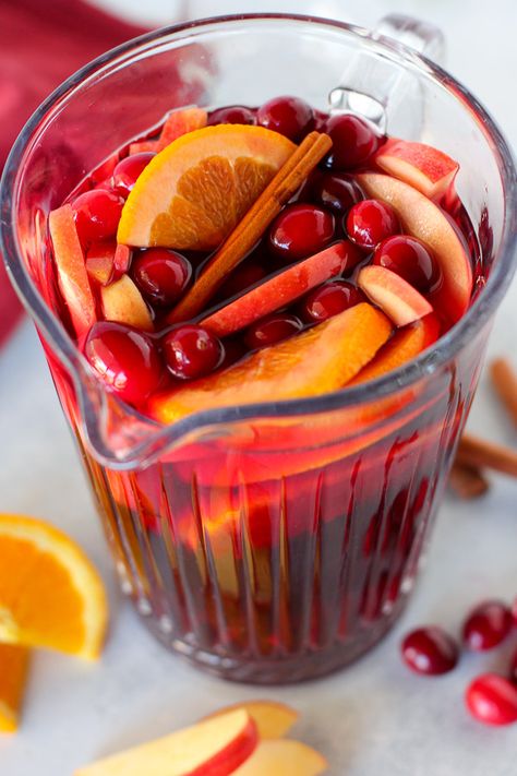 This Festive Cranberry Sangria recipe is loaded with cozy and comforting fall and winter flavors. Red wine, cranberry juice, cinnamon sticks, apples, oranges, and fresh cranberries all work together to make this the tastiest Sangria ever. Punch Alcoholic, Cranberry Sangria, Thanksgiving Cocktail Recipes, Cranberry Punch, Christmas Punch Recipes, Thanksgiving Cocktails, Holiday Punch, Christmas Punch, Jungle Juice