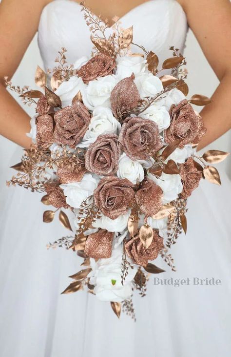 This is a cascading brides bouquet with white roses accented by rose gold glitter calla lilies, roses, and rose gold foliage. All of our wedding bouquets are made with artificial wedding flowers. Rose Gold Wedding Bridesmaids Dresses, Dusty Mauve Bridesmaid Dress Azazie, Wedding Dresses With Rose Gold, Rose Gold And Burgundy Wedding Flowers, White And Rose Gold Wedding Dress, Wedding Bouquet Gold Dress, Rose Gold Wedding Ideas Decor, Rose Gold And Brown Wedding Theme, Brown And Rose Gold Wedding