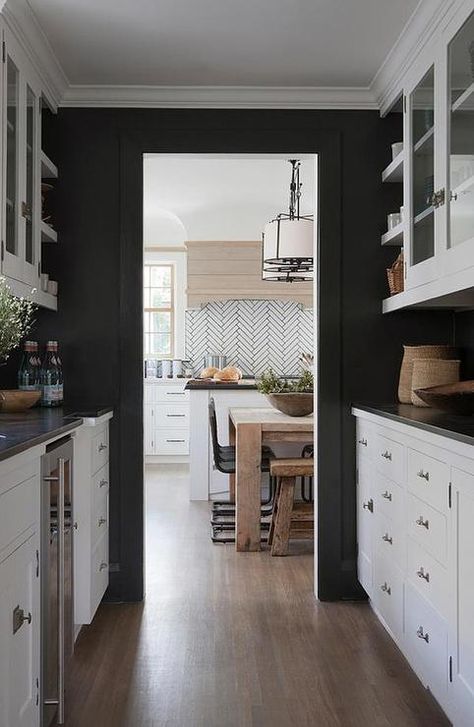 Black and white butler's pantry features walls painted black lined with white cabinets paired with black countertops. Kitchen Cabinets Black And White, Black Walls Kitchen, Black And White Cabinets, Black Painted Walls, Backsplash With Dark Cabinets, Best Kitchen Cabinets, Black Countertops, Dark Kitchen, White Backsplash