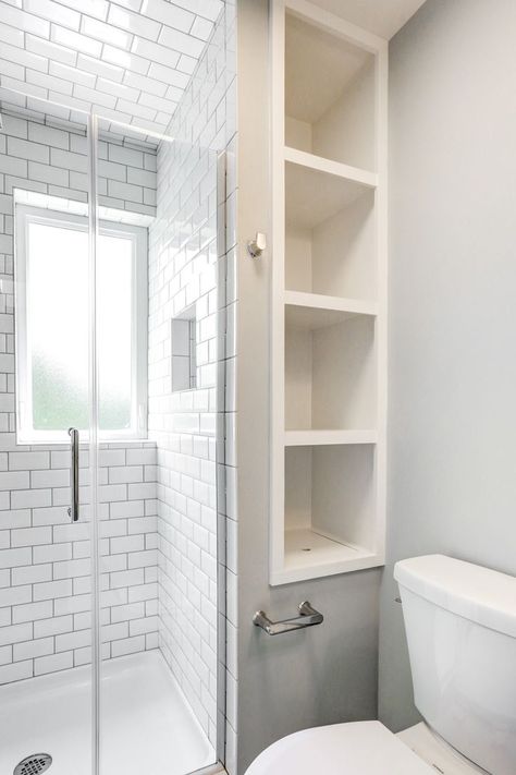 Our designer's inventive plan transformed this bathroom so drastically that it's hard to believe it's the same space. By removing a closet and adding a privacy window, we were able to relocate the shower. Swapping the vanity for a simple pedestal sink made it possible to move the sink across the room, which really opened things up. Recessed shelves in the wall provided the clients with storage without occupying extra floor space. Bathroom Vanity Extra Storage, Toilet Between Shower And Vanity, Bathroom Storage Without Closet, Shower With Side Shelves, Bathroom Inbuilt Shelves, Wasted Space In Bathroom, Walk In Shower With Storage, Storage Behind Shower Wall, Behind Shower Storage