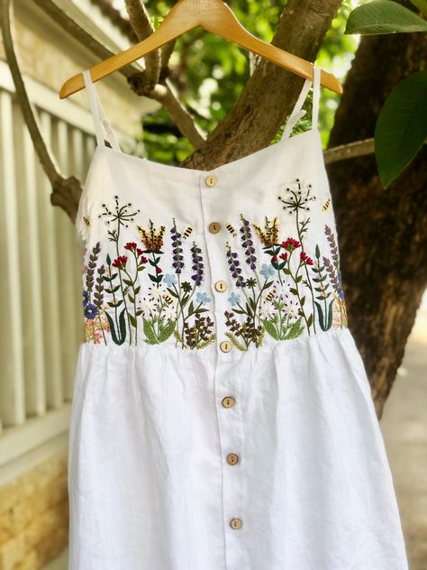 ❤ Item description: - It's a lovely dress like a mini garden with colourful embroidered flowers and bee motifs. - Material: linen, coconut button, hand embroidery. - Environmentally friendly. - This dress is very useful, go with any outfit, that can be used to go to school, go out, go shopping.    It is a perfect gift for yourself or your beloved.  ❤ Care instructions:      The best way to wash embroidery cloth is to put it in soapy water (with a mild detergent and cold water at 86 ºF/30oС) for 20 minutes. Try to not wash the item with other clothing that might cause damage, such as zippers, buttons or different colors. You wash it by hand, and if you have dirty patches on your garment, you can gently rub them, it's best not to rub directly against the embroidery. Rinse with clean water. T Embroidery On Linen Dress, Hand Embroidery Clothing, Hand Embroidery On Clothes, Hand Embroidery Clothes, Hand Embroidery Motifs, Hand Embroidered Clothes, Dress Hand Embroidery, Baby Dress Embroidery, Hand Embroidered Dress