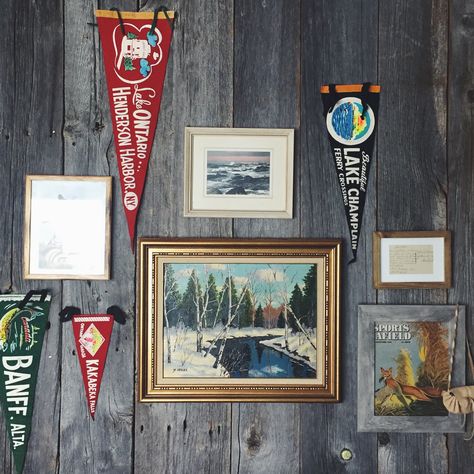 Vintage felt pennants and a hodgepodge of thrift store artwork collected over the years create this gallery wall at a north-west Ontario cabin decorated by Nicole Morell Interiors Pennant Gallery Wall, Vintage Pennants Display, Cabin Gallery Wall, Store Artwork, Cabin Vibes, Basement Reno, Thrift Store Decor, Pennant Flags, Gallery Wall Living Room