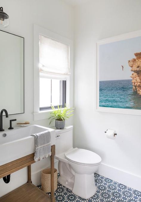 White and blue mosaic floor tiles accent a welcoming powder room featuring a salvaged wood washstand boasting a bronze gooseneck faucet fixed under a black framed mirror. White Powder Room, Pool House Bathroom, Craftsman Style Bungalow, Beachy Bathroom, Beach House Bathroom, Shed Interior, Pool Bathroom, House Vibes, Eclectic Interior Design