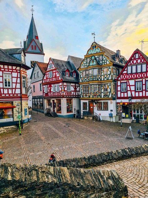 An open town square with many colourful ornate traditional German buildings and the top of a church in the distance German Houses, Scotland Road Trip, German Architecture, German Village, Instagram Locations, Cities In Germany, Instagrammable Places, Medieval Town, Beautiful Villages