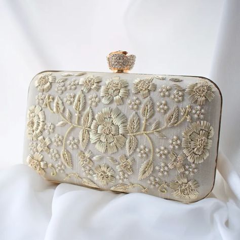 A very classy and regal ivory silk clutch embellished with light gold zardozi and pearls. Also consists of a diamante rose clasp. Super chic! not given not given Silk Silk Clutch, Bridal Handbags, Embellished Clutch, Embroidered Clutch, Pearl Accessories, Potli Bags, Bridal Clutch, Graduation Gifts For Her, Cream Silk