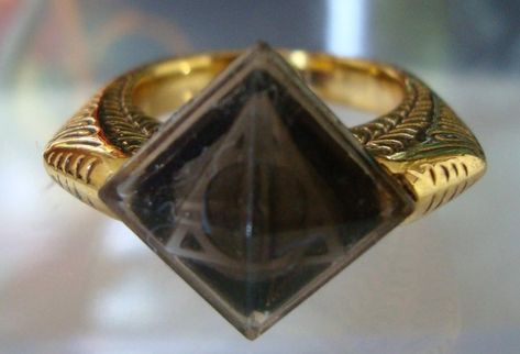 Marvolo Gaunt's Ring was an heirloom of the House of Gaunt, descendants of Salazar Slytherin and Cadmus Peverell. It is a gold ring inset with a black stone (actually the Resurrection Stone, but neither Marvolo Gaunt nor Lord Voldemort were aware of its existence) engraved with what Marvolo Gaunt called the Peverell coat of arms (having come into the Gaunt line from an heiress of the Peverells, not the Slytherin family), which is actually the symbol of the Deathly Hallows. The signet ring... Popular Song Lyrics, Yer A Wizard Harry, Neville Longbottom, Lord Voldemort, Albus Dumbledore, Harry Potter Love, Harry Potter Quotes, Harry Potter Obsession, Mischief Managed