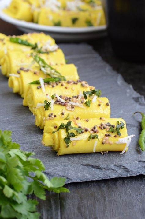 Khandvi is a popular Gujarati snack made using buttermilk and chickpea flour. Here is a recipe with tips and tricks to make perfect Khandvi. Khandvi Recipe, Gujarati Cuisine, Gujarati Snacks, Desi Street Food, Indian Recipe, Indian Breakfast, Gujarati Recipes, Indian Street Food, Chickpea Flour