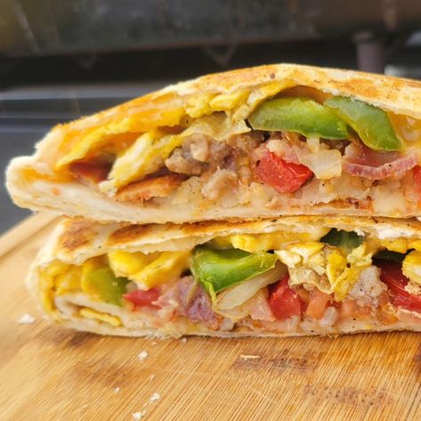 Wake up to a (Breakfast) Crunch Wrap! Filled with cheddar cheese, scrambled eggs, bacon, sausage, peppers, onions, tomatoes, and crispy hashbowns. 🪨 All cooked on a @blackstoneproducts griddle. #crunchwrap #griddlebreakfast #breakfast #thebreakfastgriller #griddlenation #griddlecrew #blackstonegriddle #greatgriddleoff24 #breakfastofchampions #breakfastfood #breakfastideas #recipeoftheday #recipeshare #recipeinspiration Breakfast Crunch Wrap, Cheese Scrambled Eggs, Scrambled Eggs Bacon, Sausage Peppers Onions, Sausage Peppers, Crunch Wrap, Bacon Sausage, Blackstone Griddle, Breakfast Of Champions