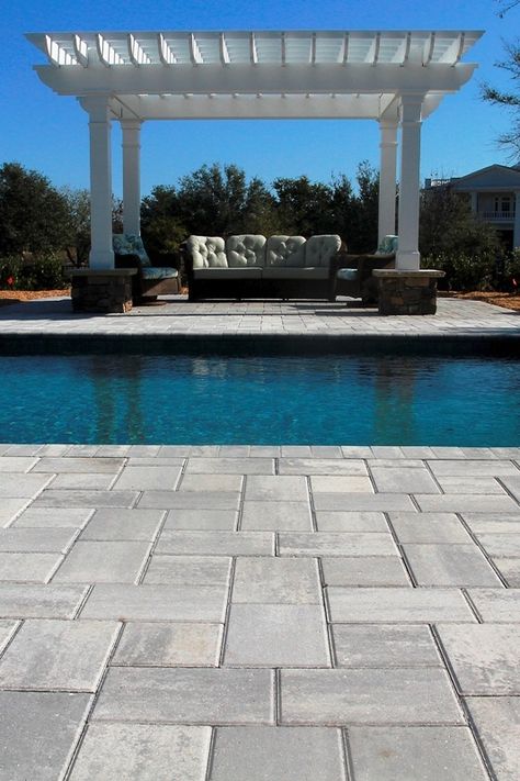 Bahama pavers in Shark Tooth gray by Jackson Landscaping cooly contrast with the alluring blue of the pool at this Landfall residence in Wilmington NC.  Stone Garden can match you with a water garden specialist or a contractor to build your pool and install the stonework that will set it off. Gray Paver Pool Deck, Pool Deck Pavers Ideas, Gray Pavers Around Pool, Concrete Pavers Around Pool, Gray Pavers Patio, Paver Pool Deck Ideas, Landscape Pavers Ideas, Gray Pool Deck, Pool Pavers And Coping