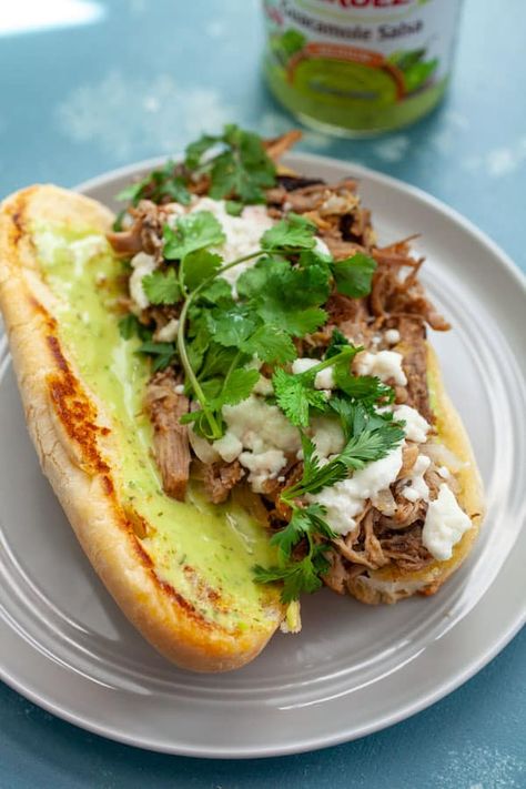 Have you had a Torta?!! It's a Mexican Sandwich that's usually filled with griddled meat, onions, and cheese, all stuffed in a soft roll. SO GOOD. I made this version with pressure cooker pulled pork and slathered it with Guacamole Salsa! macheesmo.com #tortas #pulledpork #sandwiches #mexican Mexican Food Tortas, Pork Tortas Sandwich, Carnitas Tortas Sandwich, Bollios Mexican Sandwich, Torta Recipe Mexican, Mexican Tortas Sandwich Recipes, Mexican Sandwich Recipe, Mexican Tortas Sandwich, Tortas Mexicanas Recipe