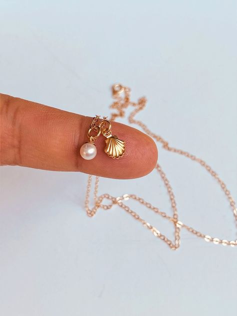 14k gold tiny seashell pearl necklace. Super cute and Super tiny charms.  This is a super, super cute necklace. It's is very simple and perfect with any outfit . This beautiful necklace consists of... -6x8.5mm 14kSea Shell Charm, -14k gold tiny pearl charm, -14k Solid gold rope chain, cable chain , or box chain, -Come up with beautiful ribbon gift box and -One set of Care instruction package . MORE SOLID GOLD AND DIAMOND JEWELRY  https://www.etsy.com/shop/rainbowearring1?ref=listing-shop-header- Gold Aesthetic Jewelry, Clam With Pearl, Gold Shell Necklace, Pearl Seashell, Tiny Charms, Surf Jewelry, Preppy Jewelry, Ribbon Gift, Necklace Charms