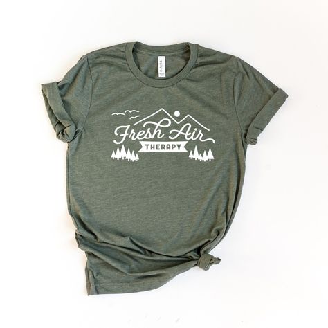 Looking for a cute versatile top to wear this summer? Make sure to grab one of our Fresh Air Therapy tees! This soft and comfortable graphic tee is the perfect top for any outfit. It can be paired with biker shorts, jeans, or even a simple skirt/dress! This tee is true-to-size, so be sure to order your regular t-shirt size! If you are looking for a more oversized look, make sure to size up! Nature Shirt Design, Nature Shirts, Fresh Air, Army Green, Graphic Tee, Top Shirt, Shirt Designs, Target, Graphic Tees