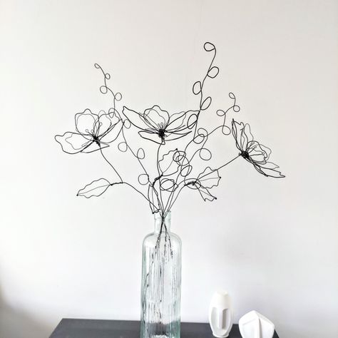 Handcrafted Wire Flower Bouquet - Minimalist Metal Floral Art Enhance your home decor with this beautiful handcrafted wire bouquet, featuring 3 delicately shaped flowers and 3 complementary stems. This minimalist metal sculpture adds an artistic touch to any space, perfect for showcasing on a table, mantel, or in a favorite vase. Product Details: Sizes: Flowers: 45 cm Stems: 55 cm Material: Crafted from durable black annealed wire. Features: Handcrafted Excellence: Each piece is meticulously sha Wire Sculpture Easy, Flower Bouquet Minimalist, Wire Art Easy, Wire Flower Bouquet, Metal Wire Sculpture, Wire Figures, Metal Flower Art, Metal Wire Art, Sculptures Sur Fil