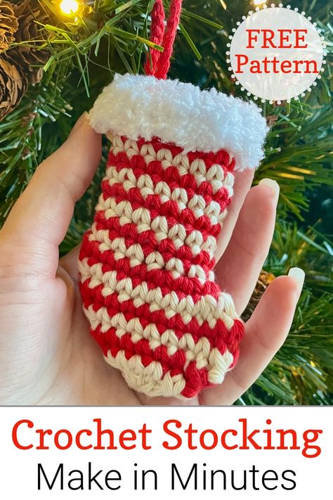 Close up of hand holding a striped crochet mini stocking decoration hanging on Christmas tree Crochet Mini Stocking Pattern Free Easy, Mini Stocking Crochet Pattern Free, Crocheted Mini Christmas Stockings Free, Small Christmas Stocking Crochet Pattern, Quick Crochet Stocking Free Pattern, Crochet Tiny Stocking, Crochet Small Christmas Stocking, Crochet Stocking Ornament Pattern Free, Crochet Small Stocking