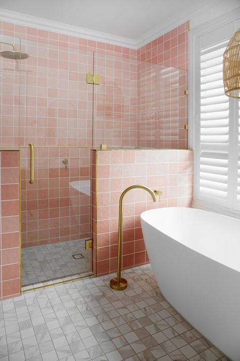 A nib wall in this modern bathroom showcases pink bathroom tiles and brass tapware including a floor-mounted bath filler next to a freestanding bathtub. Bathroom With Shower And Bath, Miami Bathroom, Aesthetic Home Design, Pink Tile Bathroom, White Square Tiles, Pink Bathroom Tiles, Oval Tub, Pretty Bathroom, Hamptons Style Home