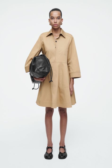 Modeled on the classic trench coat, this A-line mini dress is designed with subtle nods to utility. It's crafted from cotton with a hint of stretch and features oversized front pockets, a concealed placket and a flared skirt. Relaxed fitButton closure Shell: 98% Cotton, 2% Elastane. Lining: 100% Cotton. Excluding trims / Machine wash Back length of size 6 is 36.22" / Model wears a size 6 Belted Cape, Utility Shirt, Classic Trench Coat, Accessories Bags Shoes, Women Magazines, Cardigan Shirt, Beige Dresses, Vest Shirt, Winter Coats Jackets