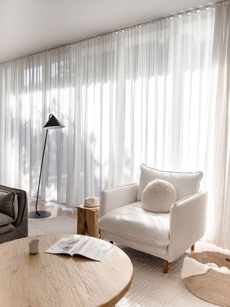 Neutral living room with a relaxed and coastal vibe. The white linen armchair, old elm wood coffee table, black floor lamp, sheer curtains and jute throw basket make this space layered in textures. Click to see more photos of this living room! Sheer Curtains Living Room, Linen Curtains Living Room, White Curtains Living Room, Sheers Curtains Living Room, Vibe White, Curtains Living Room Modern, Peacock Party, Beige Curtains, Living Room Curtains