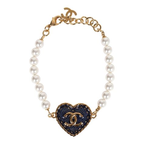 These Chanel CC denim heart and pearls bracelet features an adjustable faux white pearl chain with a CC blue enamel denim heart charm a gold tone hardware CC charm, and a lobster clasp.Origin: ItalyCondition: New and never wornAccompanied by: Box, felt jewelry cover, ribbon, carebook and retail UPC, Measurements: Length (circumference): 8" | Diameter: 2.5" ; 0.75" x 1" heart charm Chanel Jewelry Aesthetic, Chanel Bangle, Denim And Pearls, Vintage Chanel Jewelry, Black Leather Cuff Bracelet, Chanel Bracelet, Pearls Bracelet, Chanel Necklace, Brown Jewelry