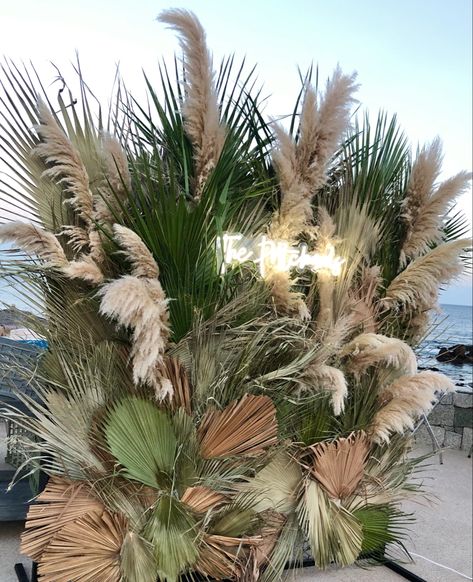 Mix of dried and green palm leaves with touches of pampas grass Decor With Palm Leaves, Palms And Pampas, Dried Palm Leaves Decor Wedding, Pompass Grass Backdrop, Dry Leaves Decoration Ideas, Palm Leaves Decoration Wedding, Paper Palm Leaves Backdrop, Dried Palm Leaves Wedding, Pampas Grass And Palm Leaves