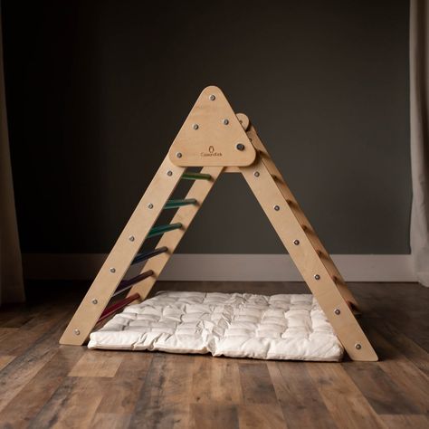 Inspire your child to dream up new, imaginative worlds with the cozy Climbing Triangle Mat. It fits perfectly under our Climbing Triangle, creating a comfy spot to let their minds wander. Surround them with their favorite stuffed animals or pile-up pillows to build a soft sanctuary of rest and relaxation. Add a blanket or our tent overtop your triangle and watch them snuggle in. This mat is designed to fit under our classic triangles. If you have the Jumbo Climbing Triangle, be sure to check out Play Structures For Kids, Waldorf Inspired Toys, Climbing Triangle, Play Structures, Triangle Pillow, Pikler Triangle, Bristol England, Play Structure, Baby Christmas Gifts