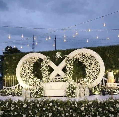 Love knows no bounds. 💍✨ Celebrating a beautiful union surrounded by pure white flowers and the infinite promise of forever. #WeddingBliss #EternalLove #infinitysymbol Unique Wedding Stage Decoration, Infinity Backdrop, Ring Ceremony Stage Decoration, Outdoor Wedding Lanterns, Reception Stage Decoration Indian Indoor, Receptions Ideas, Night Decoration, Cocktail Decor, Wedding Tent Decorations