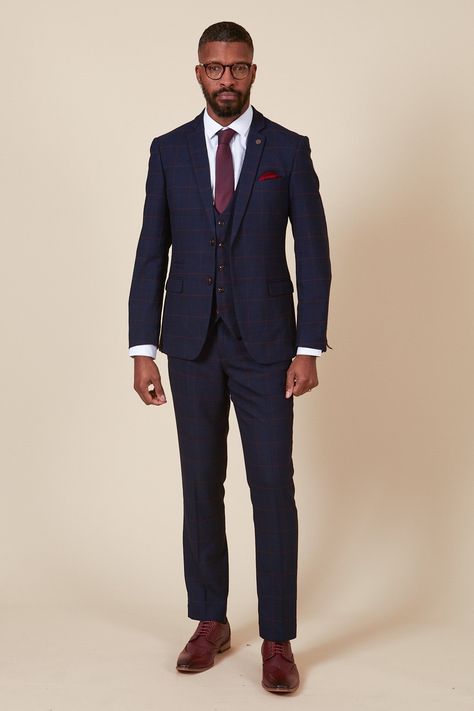 Ticking all the boxes, this men's navy three piece is simple and sophisticated in its design. Cut to a slim tailored fit, it features a deep burgundy check laden on a subtle navy Prince of Wales check. Added elastane ensures flexible easy wear that will keep you comfy from the aisle to the dancefloor. Perfect for tying in with a rich burgundy wedding theme, this suit will work for all the groomsmen. Try switching up the waistcoat for a varied look and to match the bridesmaids. Also available in Navy Blue Suit With Burgundy Tie, Navy Suit Burgundy Tie Wedding, Navy Three Piece Suit Groom, Navy Suit Maroon Tie, Men Wedding Suit Ideas, Blue Suit Burgundy Tie, Blue Suit Burgundy Tie Wedding, Three Piece Suit Mens Wedding, Blue And Burgundy Suit