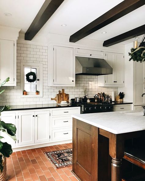 Picture of a modern farmhouse kitchen with a terracotta tile floor, a white subway tile backsplash, white shaker style cabinets, dark stained wooden beams Brick Kitchen Floor, Brick Floor Kitchen, Brick Floor, Shaker Style Cabinets, Brick Kitchen, Classic Kitchen, Brick Flooring, Old Kitchen, Modern Farmhouse Kitchens