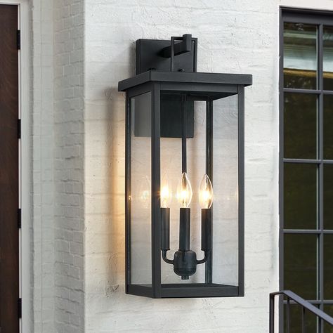 Illuminate your front door or garage with this contemporary candle style exterior wall mounted lantern sconce light. This wall lamp is rated for wet locations. Its well-constructed sturdy frames are made from metal in a powder-coated black finish, plus the 4 clear glass panels with a elongated shape enclosed in a black and sleek/elegant framework, which complements your decor from classic to rustic, ideal for Front Porch, Patio, Garage, Deck etc. Plus, it's compatible with a dimmer switch, so yo Garage Door Lanterns, Exterior Entry Lighting, Black Exterior Lights, Exterior Porch Lights, Lantern Lighting, Wall Mount Lantern, Exterior Lights, Porch Lights, Exterior Light Fixtures