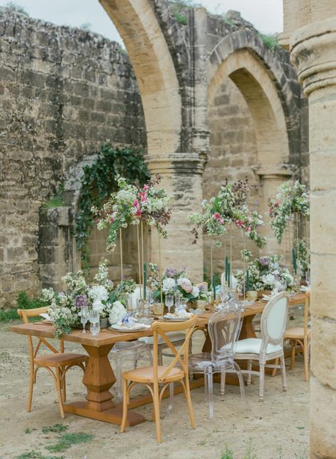 Romantic Tablescape at Agios Sozomenos Church Ruins in Cyprus with Tall Copper Frame Centrepieces, Low Wooden Crate Centrepieces and Ghost Chairs | Photographer: Antonis Prodromou | Flower Styling and Decoration: Luciana Wedding Creations And Event Planning | Location Agios Sozomenos, Cyprus | Furniture: Party City | Tableware: Party City | Wedding Gifts: Hermann Gourmet | Cosmetics: Be Mine Collection | Wedding Dress: Gala Montenapoleone | Hairstyle: Hair Spray Cyprus Michael Eliades | Makeup: Wedding Venue Cyprus, Cyprus Wedding Venues, Tuscany Wedding Theme, Trailing Bouquet, Romantic Wedding Flowers, Cyprus Wedding, Ghost Chairs, Romantic Photography, Rock My Wedding