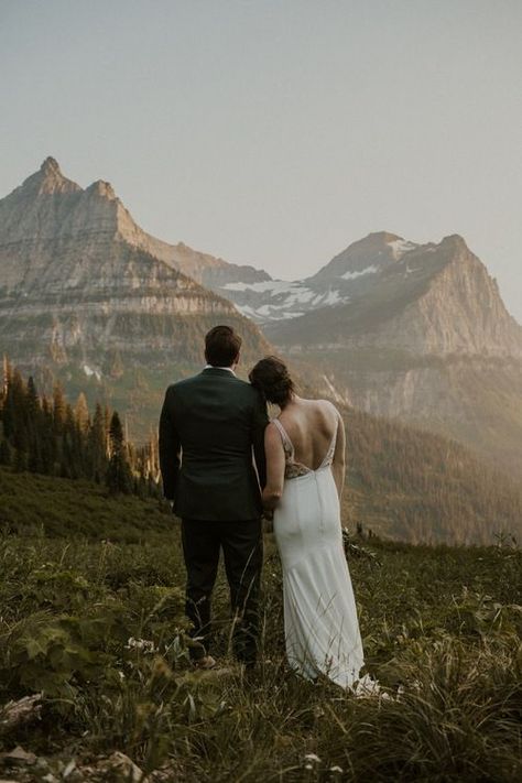 Bride and groom with their backs to the camera and looking at the gorgeous view of the Montana mountains. Visit the blog post to see these stunning wedding photos. Mountain Wedding Pictures, National Park Wedding Theme, Park Wedding Invitations, Mountain Wedding Dress, Dream Elopement, Fun Wedding Pictures, Mountain Wedding Photos, Montana Mountains, Stunning Wedding Photos