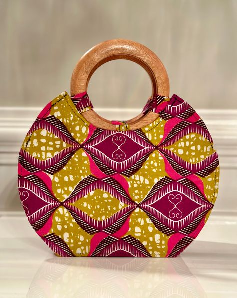 Our handmade hand bag with wooden handle is not big or too small. It’s just the right bag to fit your phone, wallet, and a few personal items. Lined with black fabric. Has an inside pocket. Zip to keep content intact. Wooden handle may vary from picture depending on piece shipped to you. Adepa is the top notch fabric in Ghana! DIMENSIONS;Length - 10 inch Width - 4 inchHeight - 8 inches (12” with handles) care : spot clean Big Hand Bag, Sequence Gown, Wooden Handle Bag, Africa Style, Bags Sewing, Wooden Bag, African Crafts, Fabric Handbags, Tote Bags Sewing