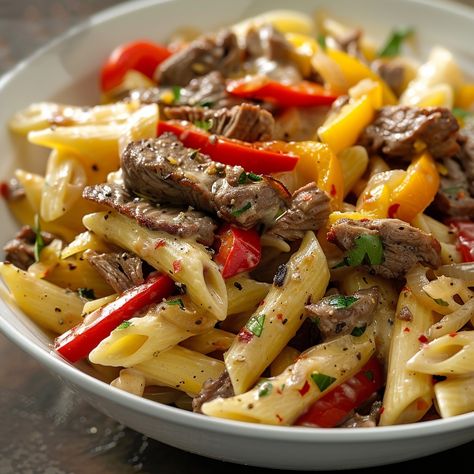 🍝 Indulge in the rich flavors of Philly Cheesesteak Pasta tonight! #PastaNight Philly Cheesesteak Pasta Ingredients: Penne pasta (1 lb) Thinly sliced beef steak (1 lb) Bell peppers, sliced (2) Onion, sliced (1) Provolone cheese, sliced (1 cup) Beef broth (1 cup) Olive oil (2 tbsp) Salt and pepper (to taste) Instructions: Cook pasta al dente; drain. Sauté beef, peppers, and onion in olive oil. Add cooked pasta, broth, and cheese; stir until creamy. Season with salt and pepper. 🍝 Enjoy our ... Easy Philly Cheese Steak Pasta, Pasta With Peppers And Onions, Philly Cheese Steak Pasta Skillet, Chicken Peppers And Onions Pasta, Roast Pepper Pasta, Beef Pasta, Bistro Food, Pasta Ingredients, Soul Food Dinner