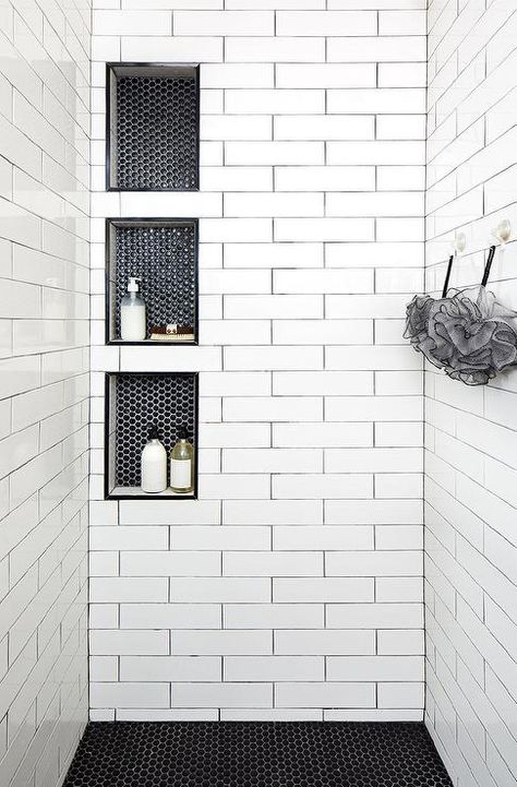 Triple stacked shower niches with black hexagon tiles surround long white shower tiles with black grout creating a unique and stylish walk-in shower design. White Shower Tile, Design Interior Baie, Tiled Shower, Bad Inspiration, Decor Baie, Shower Niche, Master Bath Remodel, White Shower, Bathroom Remodel Shower