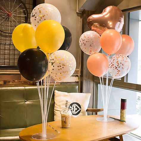 Two balloon stand kits with seven balloons each in different colors on a table in a coffee shop. Balloons On Sticks, Stick Centerpieces, Balloon Table Centerpieces, Balloon Stand, Balloon Holders, Balloons Decoration, Birthday Party Accessories, Diy Table Top, Birthday Table Decorations