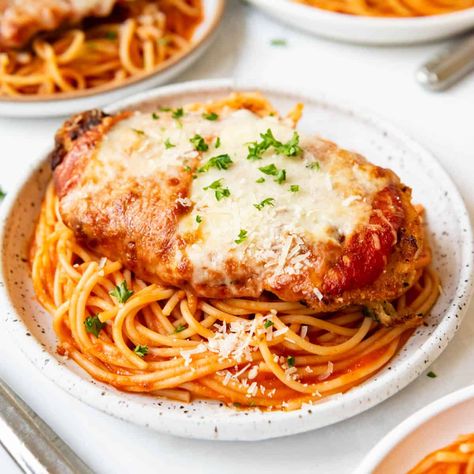 This Chicken Parmesan recipe is made with perfectly seasoned crispy chicken topped with a simple homemade tomato sauce and sliced mozzarella cheese. Pan-seared to develop the crust, then finished in the oven, we love to serve our chicken parm with spaghetti cooked just until al dente and tossed in more of the homemade sauce. #chickenparm #chickenparmesan #chickenparmigiana Chicken Parmesan With Spaghetti, Cajun Sausage Pasta, Chicken Parmesan Recipe, Parmesan Recipe, Traditional Italian Dishes, Chicken Parmigiana, Seasoned Chicken, Parmesan Recipes, Spaghetti Recipe