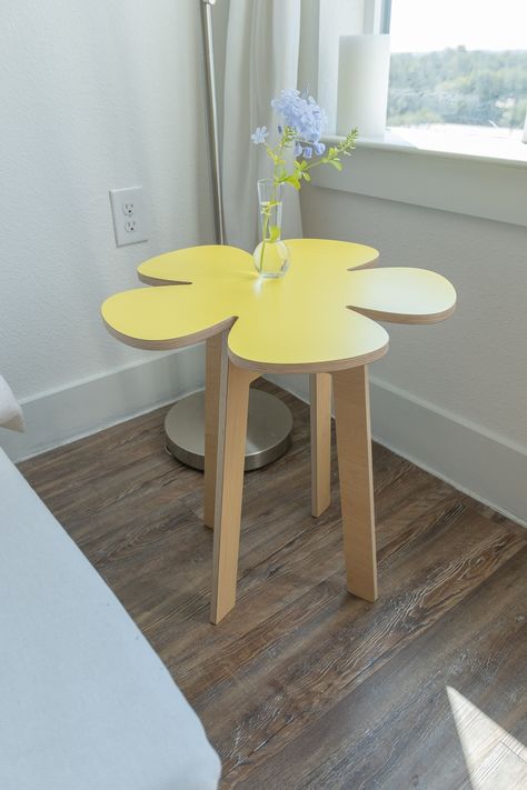 "make any room bloom with our flower power inspired collection of side tables, stools, table-top risers, coasters and even wall décor! it's flat-pack and mobile furniture so take it out on the balcony, patio, or park. all garden tabletops are designed to hang on the wall too. this flower no. 4 retro petal floral table kit includes: (1) flower no. 4 tabletop 20\" x 20\" x 1/2\" - bright yellow (1) 20\" classic modern leg-set - maple (1) olm tool to build your desk with (olm = orbit locking mechan Curvy Furniture & Decor, Furniture Inspo Aesthetic, Fun End Tables, Aesthetic End Table, Unusual Room Decor, Flower End Table, Maximalist Side Table, Flower Shaped Table, Cute Side Tables For Bedroom