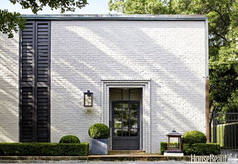 To "update and clarify" a 1961 house in Houston, architect Ray Booth of McAlpine and Elizabeth Kennedy balanced the original aesthetic with a contemporary point of view. Booth tweaked the '60s white-brick facade with new vertical shutters and added a steel-gated front door and custom lantern. Modern Southern Home, Painted Brick House, Pintura Exterior, Facade Lighting, Shutters Exterior, Brick Facade, Casa Exterior, White Brick, Design Exterior