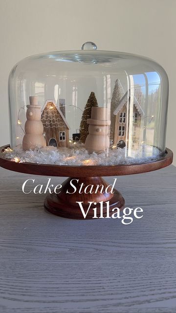 Missie Denise | Content Creator on Instagram: "Soooooo I came this DIY cake stand village and I absolutely fell in love. I immediately ran to @target to grab ALL the things then ran home to recreate it. Cake stand- threshold Snow flurries Snowman Houses Bottle brush trees Dewdrop lights Original on @stephanie hannablog #targetfinds #christmasdecor #christmasvillage #cakestand #target #targetdollarspot #targetchristmas #diy #diyholidaydecor #cakestand #thresholdtarget #tabletopdecor #kitche Cake Dome Decor, Christmas Cake Stand, It Cake, Mini Cake Stand, Cake Stand Decor, Diy Cake Stand, Christmas Cocktail Party, Glass Vase Decor, Target Christmas