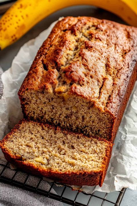 Overhead view of a gluten-free banana bread loaf with one slice cut, resting on a parchment-lined cooling rack next to ripe bananas. Gluten Free Banana Bread Recipe Moist, Gf Banana Bread Recipe, Pizza Crust Easy, Using Ripe Bananas, Gluten Free Pizza Crust Easy, Almond Banana Bread, Greek Yogurt Banana Bread, Dairy Free Banana Bread, Banana Bread Easy