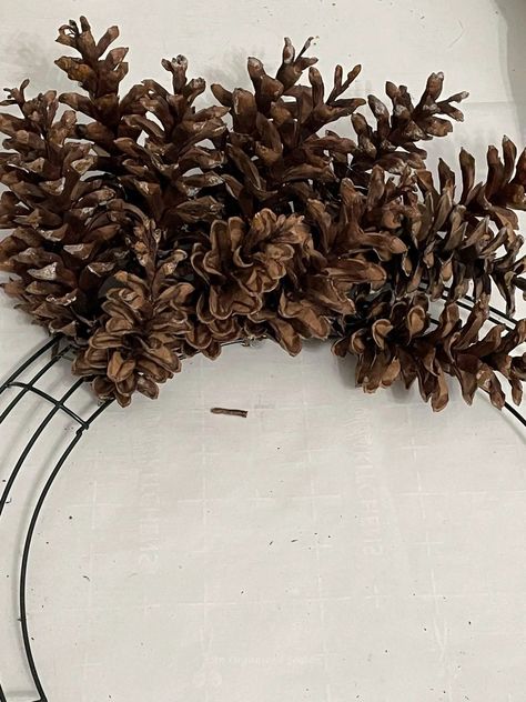 Do you have pinecones in your yard? Go outside, gather them up, and let's make an amazing pinecone wreath for Winter! Tutorial on how to attach pinecones to a wreath form and how to paint it white! Please pin this and follow us for more DIY and seasonal decor inspiration! Small Pine Cone Wreaths, Big Pine Cones Christmas Decor, Crafts Made With Pinecones, Wire Frame Wreath Tutorial, Christmas Wreaths With Pine Cones, Cabin Wreath Ideas, Diy Pinecone Wreath How To Make, Pinecone Wreath Tutorial, How To Make Pine Cone Wreaths