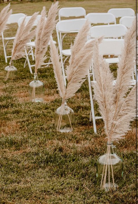 Pampas Grass In Jugs Wedding, Boho Chic Wedding Aisle Decor, Rustic Wedding Decor Aisle, Pompous Grass Wedding Decorations, Small Wedding Ideas Western, Pampas Grass Ceremony Decor, Pompis Grass Wedding Decor, Boho Wedding Ideas Decoration Diy, Wine Jug Wedding Decor