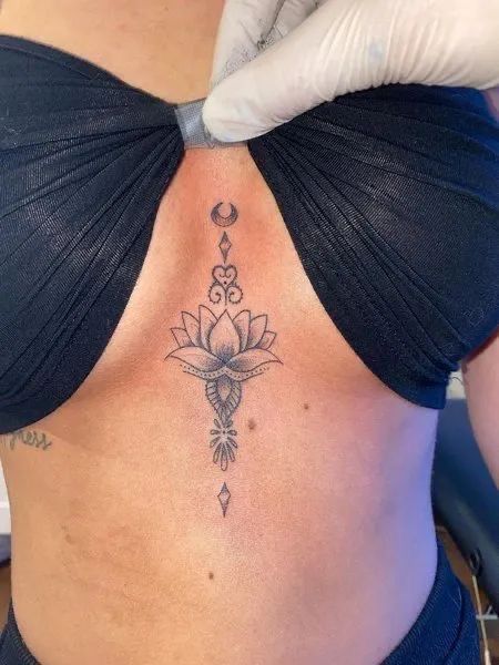 Tattoo Ideas On Sternum, Sternum Tattoos Black Women, Women’s Underboob Tattoo, Henna Underboob Tattoo, Lotus Flower Tattoo Under Breast, Underboob Lotus Tattoo, Lotus Flower Tattoo Between Breast, Womens Underboob Tattoo, Flower Between Breast Tattoo