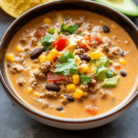 Delicious creamy taco soup with ground beef, beans, and spices. Perfect for a cozy meal. Ready in 30 minutes! Taco Rice Soup Ground Beef, Taco Soup With Cream Cheese Ground Beef, Easy Creamy Taco Soup, Ground Beef Recipes Soup, Taco Soup With Cream Cheese, Ground Beef Soups, Soups With Ground Beef, Ground Beef Taco Soup, Creamy Taco Soup Recipe