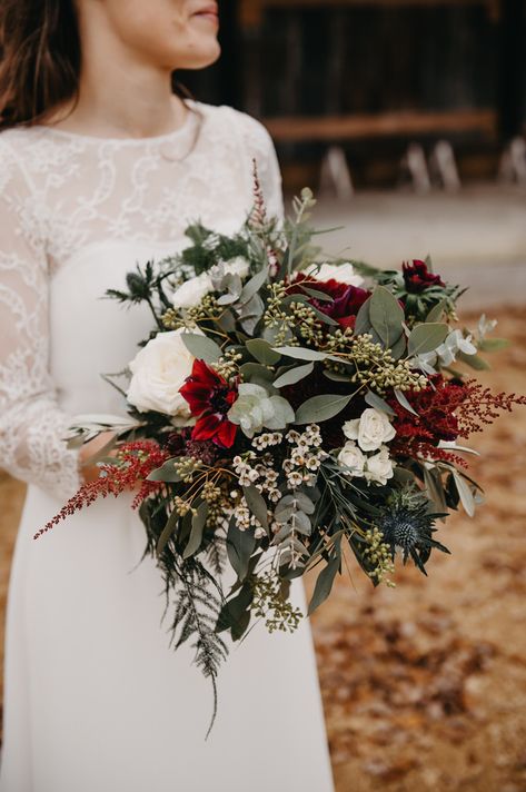 Red and white wedding florals with dark green foliage for a winter barn wedding. Red Green And Champagne Wedding, White Green And Burgundy Wedding Flowers, Forest Green And Dark Red Wedding, Emerald Green And Burgundy Winter Wedding, Red And Green Bouquet Wedding, Red White And Green Wedding Bouquet, Sage Green And Burgundy Wedding Bouquet, Winter Wedding Floral Arch, Red And Green Wedding Bouquet