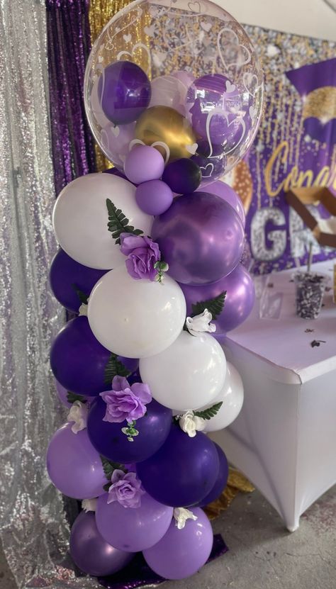 Balloon column, flowers, graduation Graduation Purple Theme, Balloon Columns With Flowers, Butterfly Balloon Column, Purple Balloon Columns, Purple And White Graduation Party, Purple And White Graduation Party Ideas, Purple Graduation Party Ideas, Purple And Gold Party Decorations, Balloon Centerpieces Diy