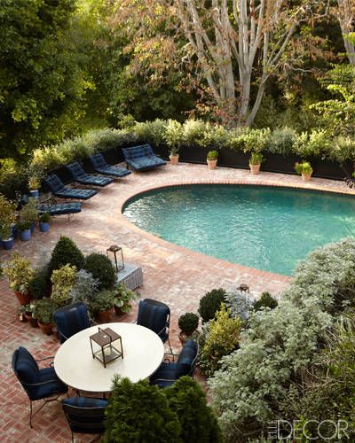 In the pool area, the concrete dining table is by Mecox Gardens, the iron chairs are topped with cushions covered in a Ralph Lauren Home fabric, and the brick pavers are original. Ideas De Piscina, Pool And Patio, Iron Chairs, Oval Pool, Moderne Pools, Living Pool, Brick Pavers, Dream Pools, Brick Patios