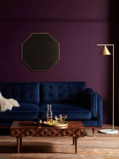 an exquisite living room with a deep purple accent wall, a navy sofa, a beautiful wooden coffee table and a gold floor lamp Purple Accent Wall, Purple Accent Walls, Purple Living Room, Purple Bedroom, Purple Walls, Paint Colors For Living Room, A Living Room, Living Room Paint, Room Colors